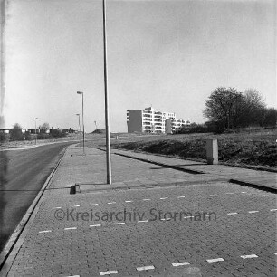 Poggenbreeden: vorne Parkplätze, im Hintergrund rechts das Wohngebäude der Wohnstättengenossenschaft e.G. Bad Oldesloe, links Wohngebäude des Fuchsberg: Blick nach Nordwesten