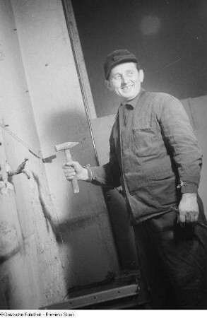 Porträt eines Arbeiters mit Hammer und Meißel auf der Baustelle Doktor-Hermann-Duncker-Straße