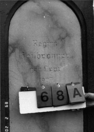 Grabstein 68 (Index: 99798582) Material: Sandstein, Schriftplatte Marmor Zustand: gut, Abschluß leicht beschädigt Maße HxBxT: 225x55x27 cm Beschreibung: Stele mit giebelartigem Abschluß, Schriftplatte mit Rundbogenabschluß, Sockel: Grabstein 68A