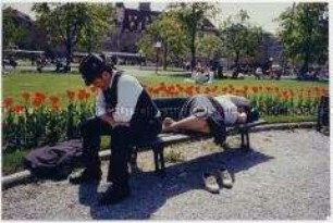 Frau und Mann ruhen sich auf einer Parkbank aus (Sonderthema: Traum-Bilder)