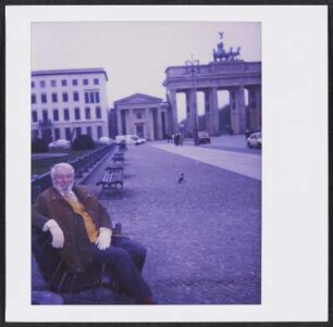 Wolfram Siebeck sitzt vor dem Brandenburger Tor auf einer Bank