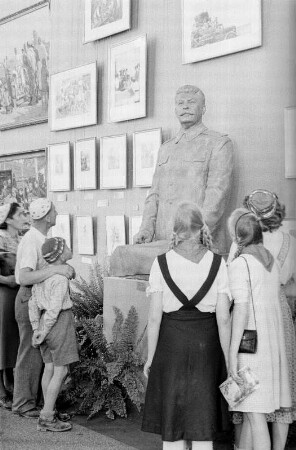 Ausstellung der Sowjetunion im Gebäude des Finanzministeriums der DDR am Werderschen Markt anlässlich der III. Weltfestspiele in Berlin : Ausstellungsbesucher vor einer Plastik von Josef Stalin