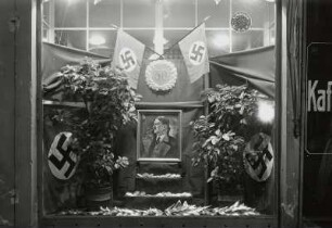 Roßwein. Schaufensterdekoration im Kaffeeladen Thams & Garf zu Adolf Hitlers 50. Geburtstag am 20.4.1939 mit Hitlerportrait und Hakenkreuzfahnen