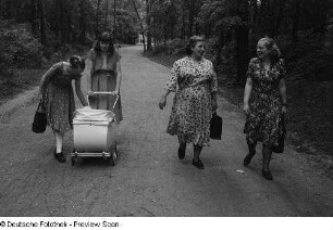 Renate Rössing (2.v.l.) mit einem Kinderwagen und drei Frauen, einen Parkweg entlanggehend