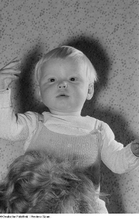 Portrait eines Kleinkindes auf den Schultern einer erwachsenen Person