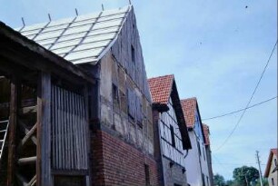 vorn Gebäude des "Lebenshofes", aktuell in der Sanierung; Reihe von Hausgiebeln entlang der Straße
