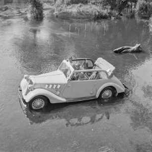 Personenkraftwagen Borgward Hansa 1100 Cabriolet mit offenem Verdeck in einem Gewässer