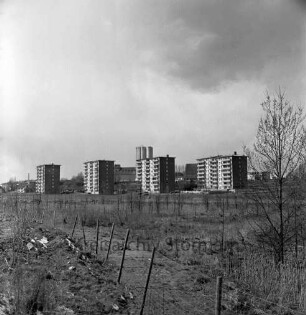 Masurenweg: vorne Grünflache Richtung Industriestraße, dahinter Wohnhochhäuser, im Hintergrund Gebäude der Firma Johannes Ströh