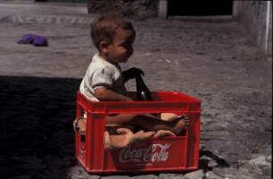 Kap Verde. Kind spielt mit einer Coca-Cola-Kiste auf der Insel Fogo
