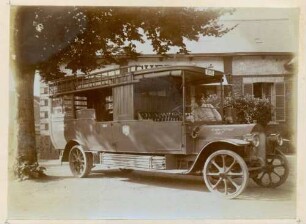 Foto eines als Bauwagen genutzten Omnibusses der Firma Benz mit auf dem Trittbrett geladenen Stangen