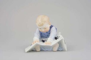 Plastik: Kind mit Bilderbuch