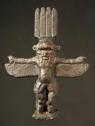 Ägyptische Besstatuette. "Statuette des geflügelten Bes, der über den gespreizten Flügeln die Arme ausstreckt. Er ist lang gekränzt. Auf dem Haupte eine Art Krone aus 4 Federn."