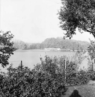 Herrenteich: Blick vom Ostufer nach Westen: im Vordergrund Hecken, Baum: am gegenüberliegenden Ufer Badeanstalt