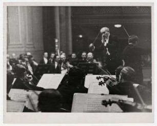 Arturo Toscanini dirigiert in Baltimore, Maryland. Konzert mit dem Geiger Adolf Busch. Arturo Toscanini, rechts stehend: Adolf Busch