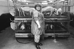 Landleben. Schweinestall : Sermuth. Portrait einer Arbeiterin in einem Schweinestall, beim Schweine tränken
