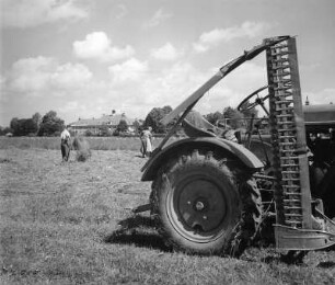Erntebilder. Heuernte. Erntemaschine auf abgeerntetem Feld