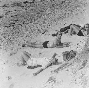 Elisabeth Gremmler und weitere Personen liegen am Strand