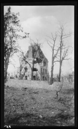Château de la Bôve (Dep. Aisne, Frankreich): Ansicht des sehr stark beschädigten Schlosses (Distanzaufnahme), im Vordergrund nackter Erdboden und wenige kahle Bäume