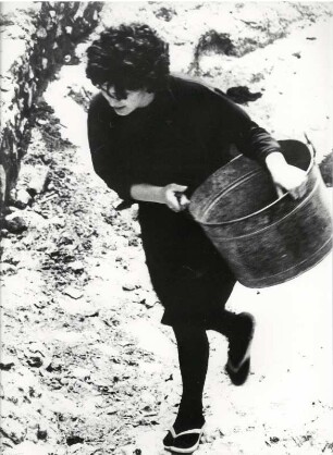 Junge Frau beim Wasserholen