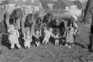 Kinder beim Spielen : Mädchen mit Puppenwagen und Spielzeugpuppen
