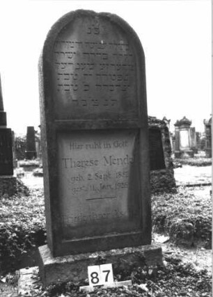 Grabstein 87 (Index: 99808515) Material: Sandstein Zustand: am Abschluß leicht beschädigt Maße HxBxT: 132x50x22 cm Beschreibung: Stele, Sockel, Rundbogenabschluß, Schriftfelder eingetieft: Grabstein 87