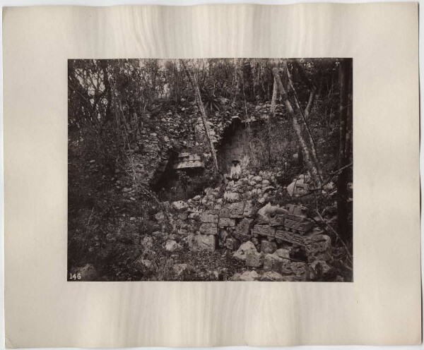 "Casa 2." In the foreground, sculpted stones (fragments). Expedition member in the background.