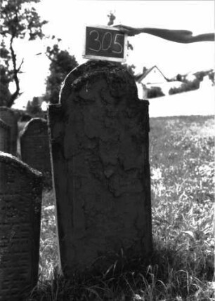 Grabstein 305 (Index: 100102400) Material: Sandstein Zustand: stark verwittert, abgeblättert, vollständiger Textverlust Maße HxBxT: 127x55x4 cm Beschreibung: Stele, eingezogener Rundbogenabschluss: Grabstein 305