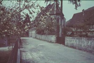 Deutschland. Straßenbild mit Kirche und Einfriedungsmauer