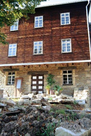 alte Mühle: zweiflügelige Tür, verbretterte Fassade, Sprossenfenster mit acht Scheiben