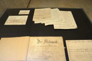 Ausstellungsvitrine mit Partituren (Abschrift der Oper "Der Alchimist")
