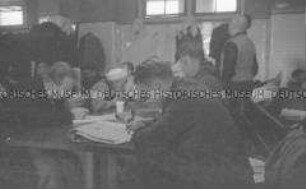 Selbstversenkung des Hochseepassagierdampfers "Columbus" am 19. Dezember 1939, Besatzungsangehörige im Internierungslager auf Ellis Island, im Aufenthaltsraum lesend, schreibend