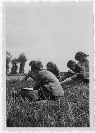 Lesende Kinder auf einer Wiese