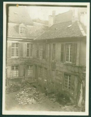 Zweigeschossiges Hinterhaus, Hof mit Bauschutt und Hundehütte.
