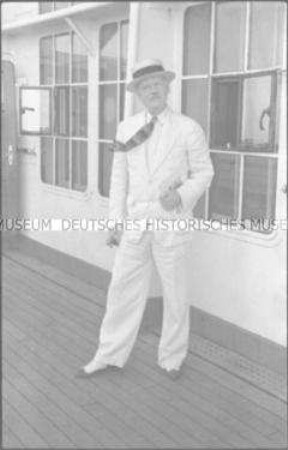 Herr in weißem Anzug an Deck des Hochseepassagierdampfers "Bremen"