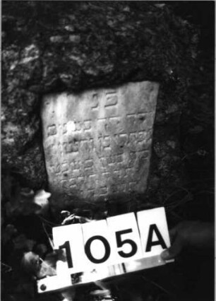 Grabstein 105 (Index: 100085531) Zustand: Schriftplatte auf Vorderseite entfernt Maße HxBxT: 50x45x24 cm Beschreibung: grob stelenhaft behauener Stein, rechteckige Schriftplatten: Grabstein 105A