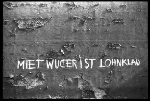 Fassade mit Inschrift "Mietwucher ist Lohnklau"