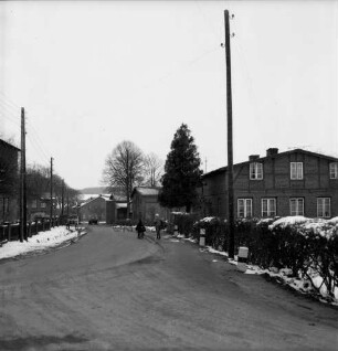 Dorfstraße mit Bauernhäusern: im Hintergrund Schulkinder: Winter