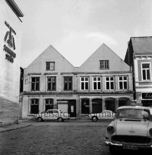 Mühlenstraße: zwei Wohn- und Geschäftshäuser vor Abriss neben Eisdiele: vorn Mühlenplatz: rechts Pkw: links Hauswand mit Firmenlogo der Johannes Ströh Mühlenwerke: 1. März 1967