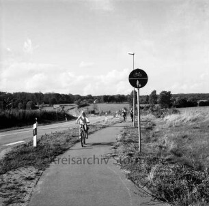 Radweg an Straße Weizenkoppel nach Rehhorst: Fahrradfahrer, Kind auf Fahrrad: Verkehrsschild, Straßenlampe