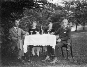 Mittelsachsen, Zwei Paare an einem Tisch : Mittelsachsen. Zwei Paare trinken zusammen an einem Tisch im Garten Wein