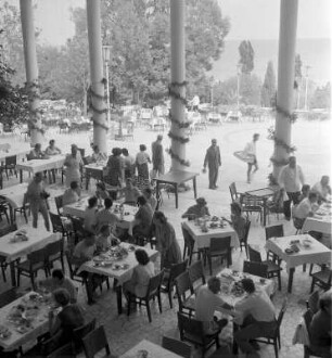 Blick auf die Terrasse eines mit Gästen gefüllten Strandrestaurants