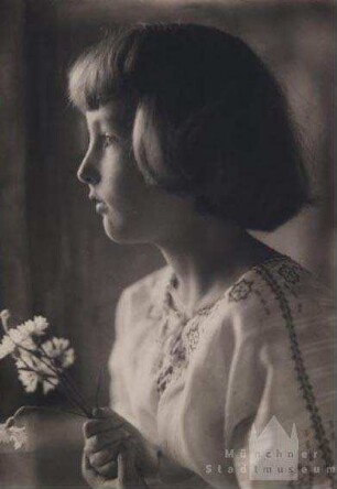 Kleines Mädchen mit Blumen in der Hand, im Profil fotografiert