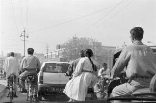 Straßenansicht mit Fahrradfahrern, Autos und Mopedfahrern, Neu-Delhi