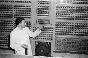 Elektronenrechner auf Röhrenbasis. Mitarbeiter vor der Hardware stehend