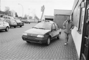 Autohaus Frenkler: Gänseberg: Hof: Vorstellung von neuem Renault 19 Chamade, mit Aufschrift "Testen": Mann: rechts Eingang zu Büro, dahinter Werkstatt: auf Parkplatz Autos, Renault-Firmenschild