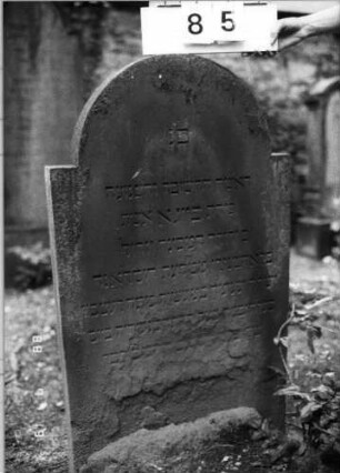 Grabstein 85 (Index: 100094782) Material: Sandstein Zustand: unten abgeblättert mit Textverlust Maße HxBxT: 122x68x9 cm Beschreibung: Stele, eingezogener Rundbogenabschluß: Grabstein 85