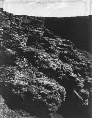 Felswand : Zerklüftete Felswand aus Serizitschiefer von Quarzgängen durchzogen.