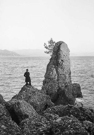 Genua/ Italien: In der Bucht, einzelner Herr auf Fels am Ufer stehend