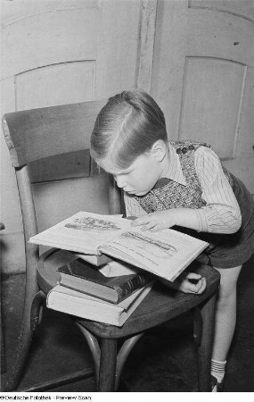 Porträt eines kleinen Jungen beim Lesen eines Buchs