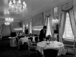 München. Im Restaurant des Hotels "Vier Jahreszeiten" decken Kellner Tische ein. Aufgenommen 1972
